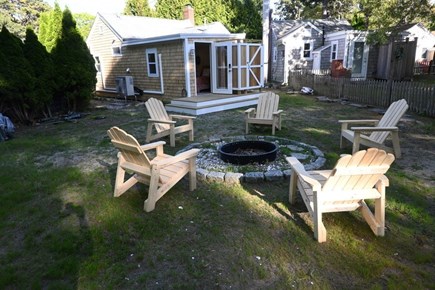 East Sandwich Cape Cod vacation rental - Back yard fire pit, adirondack chairs and outdoor shower.