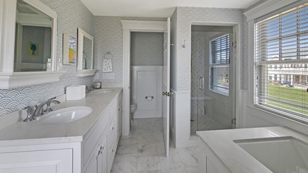 East Falmouth Cape Cod vacation rental - Second floor primary ensuite bathroom with shower, tub and WC