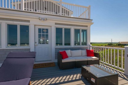 East Sandwich Cape Cod vacation rental - Back deck off of the sunroom, great for family gatherings while sitting by the water.