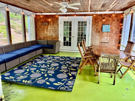 Wellfleet Cape Cod vacation rental - Screened-in-porch, wrap around couch, and large dining table.