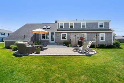 South Yarmouth Cape Cod vacation rental - Back patio with outdoor shower, seating, and oversized umbrella.