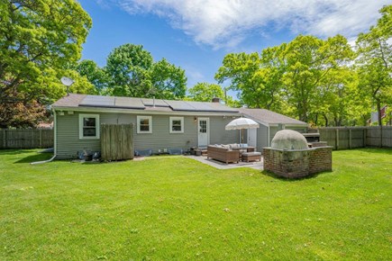 South Yarmouth Cape Cod vacation rental - Backyard with outdoor shower, patio area, and grill/oven