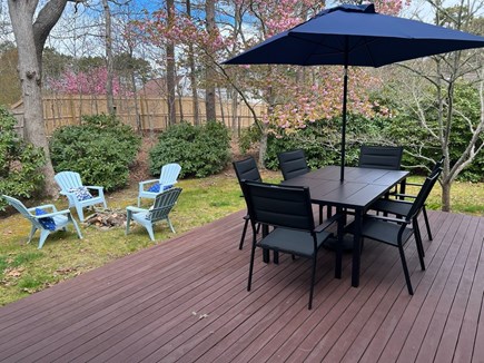 Eastham Cape Cod vacation rental - Deck with table chairs firepit, fenced yard