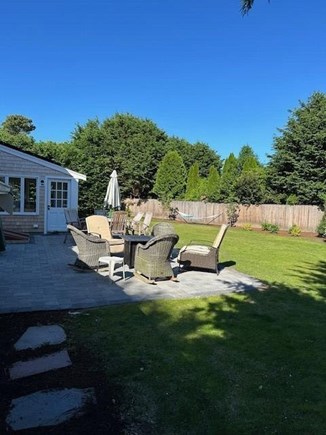 Falmouth Cape Cod vacation rental - Patio in back yard with Firepit, Teak Table and Weber Grill