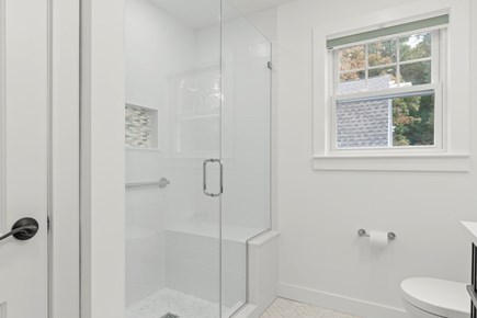 West Falmouth Cape Cod vacation rental - First floor bathroom shower with bench, rain head, and hand wand