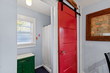 Provincetown Cape Cod vacation rental - The bathroom features a distinctive red sliding door and shower