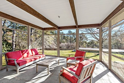 Wellfleet, Griffins Island Hideaway Cape Cod vacation rental - Screened porch with cushioned seating and views of the backyard