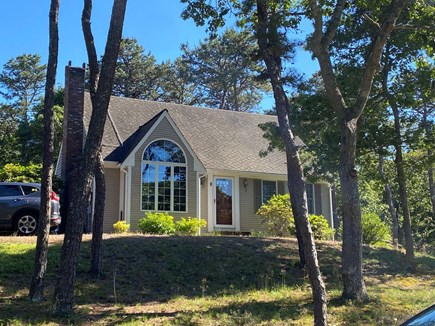 Eastham Getaway Cape Cod vacation rental - Classic Cape exterior with arched window and wooded setting