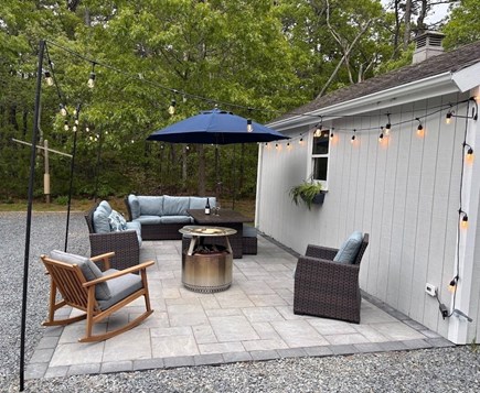 Eastham Getaway Cape Cod vacation rental - Fire pit patio with cushioned seating and cafe lights