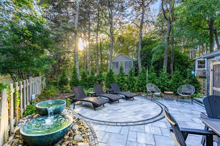 Truro Cape Cod vacation rental - Private patio with lounges, dining table, and water feature.