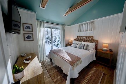 Truro Cape Cod vacation rental - Primary bedroom with queen bed and peaceful patio views.