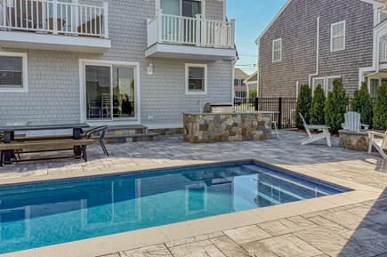 Sandwich Cape Cod vacation rental - View of the back of the home with the bar, picnic table, and fire pit
