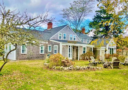 West Harwich Cape Cod vacation rental - Back of House with Fire Pit surrounded by Adirondack Chairs