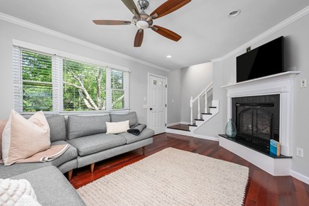 Yarmouth Port Cape Cod vacation rental - Living room with TV and stairs leading to the bedrooms on second floor