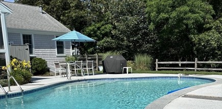West Dennis Cape Cod vacation rental - Dining table with umbrella next to pool