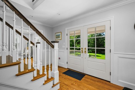 Harwich Port Cape Cod vacation rental - Formal front entry and staircase act as a transition area to the additional spaces offered within the main level.