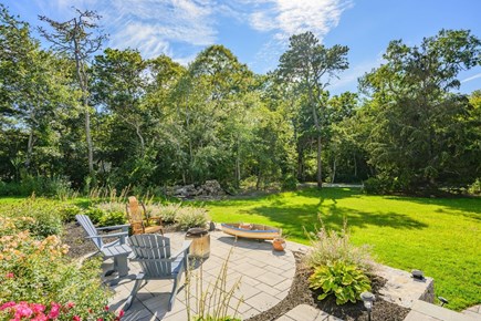 Harwich Port Cape Cod vacation rental - Front patio area with Adirondack chairs overlooking expansive front yard.