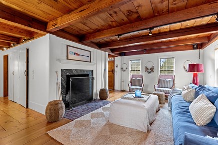 Eastham, Bridge Meadow Cape Cod vacation rental - Living room with fireplace, beams, and relaxed coastal style