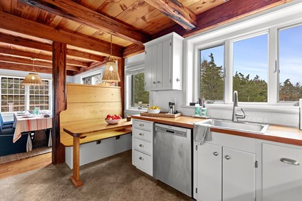 Eastham, Bridge Meadow Cape Cod vacation rental - Kitchen with farmhouse bench, sink, and treetop views