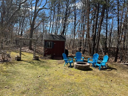 Eastham Cape Cod vacation rental - Backyard firepit with Adirondack seating and shed