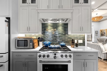 Provincetown, The Tucker House Cape Cod vacation rental - Kitchen with gas range, custom cabinets, tile backsplash.