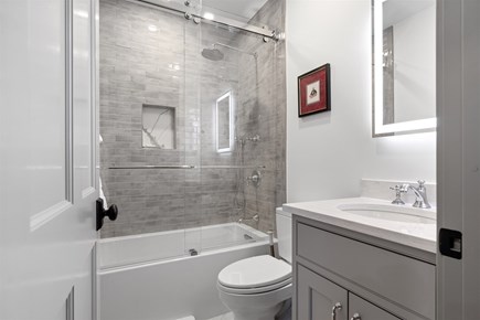 Provincetown, The Tucker House Cape Cod vacation rental - Full bathroom with glass shower and timeless finishes.