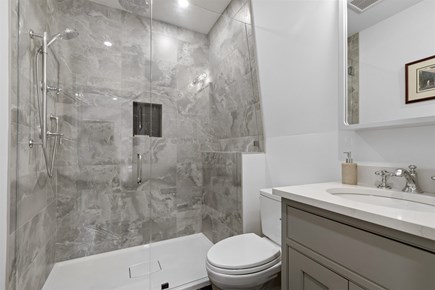 Provincetown, The Tucker House Cape Cod vacation rental - Upstairs bathroom with stone tile and walk-in glass shower.