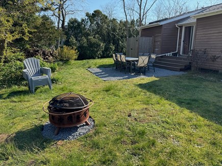 Eastham Cape Cod vacation rental - Backyard area with fire pit, table and chairs and outdoor shower