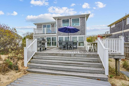 Bourne, Buzzards Bay Cape Cod vacation rental - View of the back deck, showcasing a welcoming outdoor space designed for relaxing, dining, and enjoying the surrounding views.