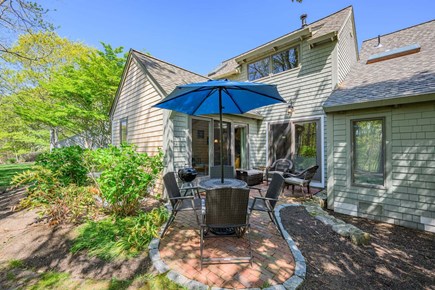 New Seabury, Mashpee Cape Cod vacation rental - Back patio with an outdoor dining table, offering a comfortable space for al fresco meals