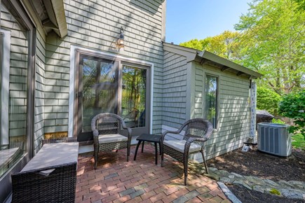 New Seabury, Mashpee Cape Cod vacation rental - Patio with seating, offering a comfortable outdoor space to relax, unwind, and enjoy the surrounding natural setting.