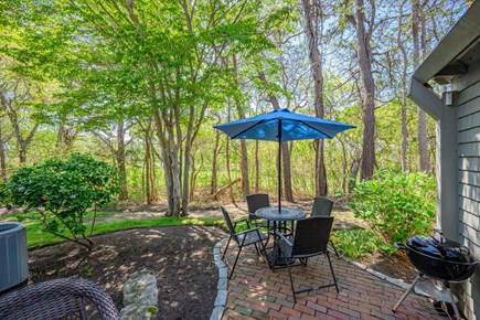 New Seabury, Mashpee Cape Cod vacation rental - Back patio with beautiful landscaping, creating a peaceful outdoor setting surrounded by greenery and space for relaxing or entertaining