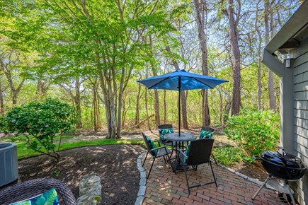 New Seabury, Mashpee Cape Cod vacation rental - Back patio with beautiful landscaping, creating a peaceful outdoor setting surrounded by greenery and space for relaxing or entertaining