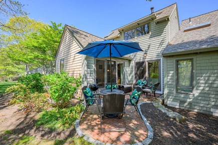New Seabury, Mashpee Cape Cod vacation rental - Back patio with an outdoor dining table, offering a comfortable space for al fresco meals