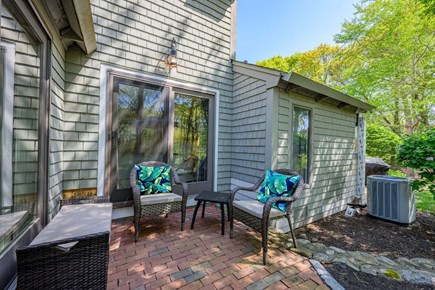 New Seabury, Mashpee Cape Cod vacation rental - Patio with seating, offering a comfortable outdoor space to relax, unwind, and enjoy the surrounding natural setting.
