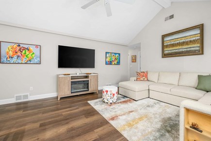 Mashpee Cape Cod vacation rental - A bright and inviting living room featuring comfortable seating and a TV, creating a cozy space to relax and unwind
