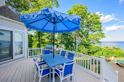 Plymouth MA vacation rental - Outdoor dining table and grill on the back deck, creating the perfect setup for al fresco meals