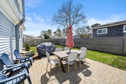 Dennis Port Cape Cod vacation rental - Backyard with clothesline, grill, dining area, and outdoor shower