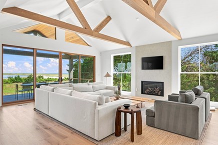 Orleans, Nauset Tide Cape Cod vacation rental - Coastal living room with fireplace, beams and water-view sliders.
