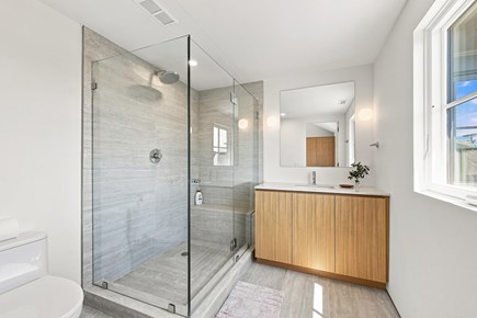 Orleans, Nauset Tide Cape Cod vacation rental - Bright bath with a glass shower, wood vanity and modern fixtures