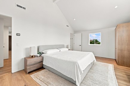 Orleans, Nauset Tide Cape Cod vacation rental - Spacious bedroom with king bed, wood furniture and soft lighting
