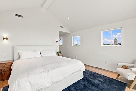 Orleans, Nauset Tide Cape Cod vacation rental - Queen bedroom with wood bed, woven rug and a large sunny window
