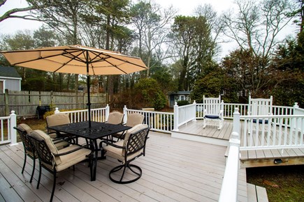 Centerville Cape Cod vacation rental - Backyard includes large deck, fire pit, swing set, and cornhole