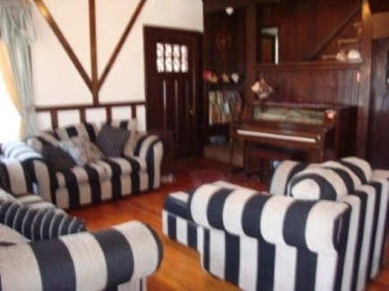Falmouth Cape Cod vacation rental - Living room with old fashioned player piano and fireplace.