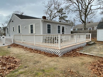 Dennis Cape Cod vacation rental - Large backyard with big deck with patio tables and chairs.