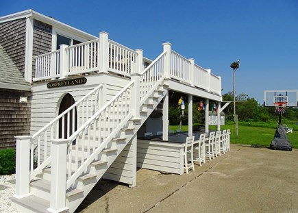 West Dennis Cape Cod vacation rental - Showing outside dining area with grill and stairs to upper deck 