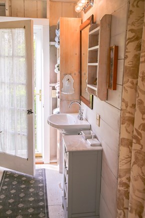 Chilmark, Guest Cottage Martha's Vineyard vacation rental - Bathroom door to outdoor shower. Washer dryer behind curtain.